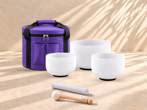SOUL: tres cuencos blancos con bolso de nylon violeta mate y dos baquetas paralelas sobre piedra marfil, ambientación digital.