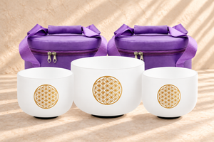 Ambientación digital: Dos bolsas moradas con tres cuencos de diseño dorado; no es una fotografía de una sesión real